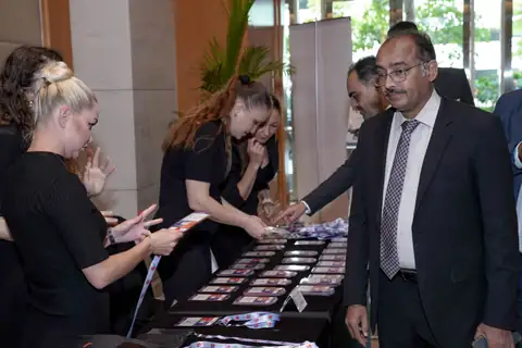 A suited delegate collects materials from a registration table at an industry event.