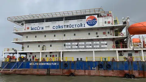 Crew stand along the blue hull below the white Miclyn Constructor I accommodation block and orange lifeboats.